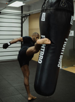 Close-up of a muscular, Caucasian male with brunette hair working mitts for muay thai.